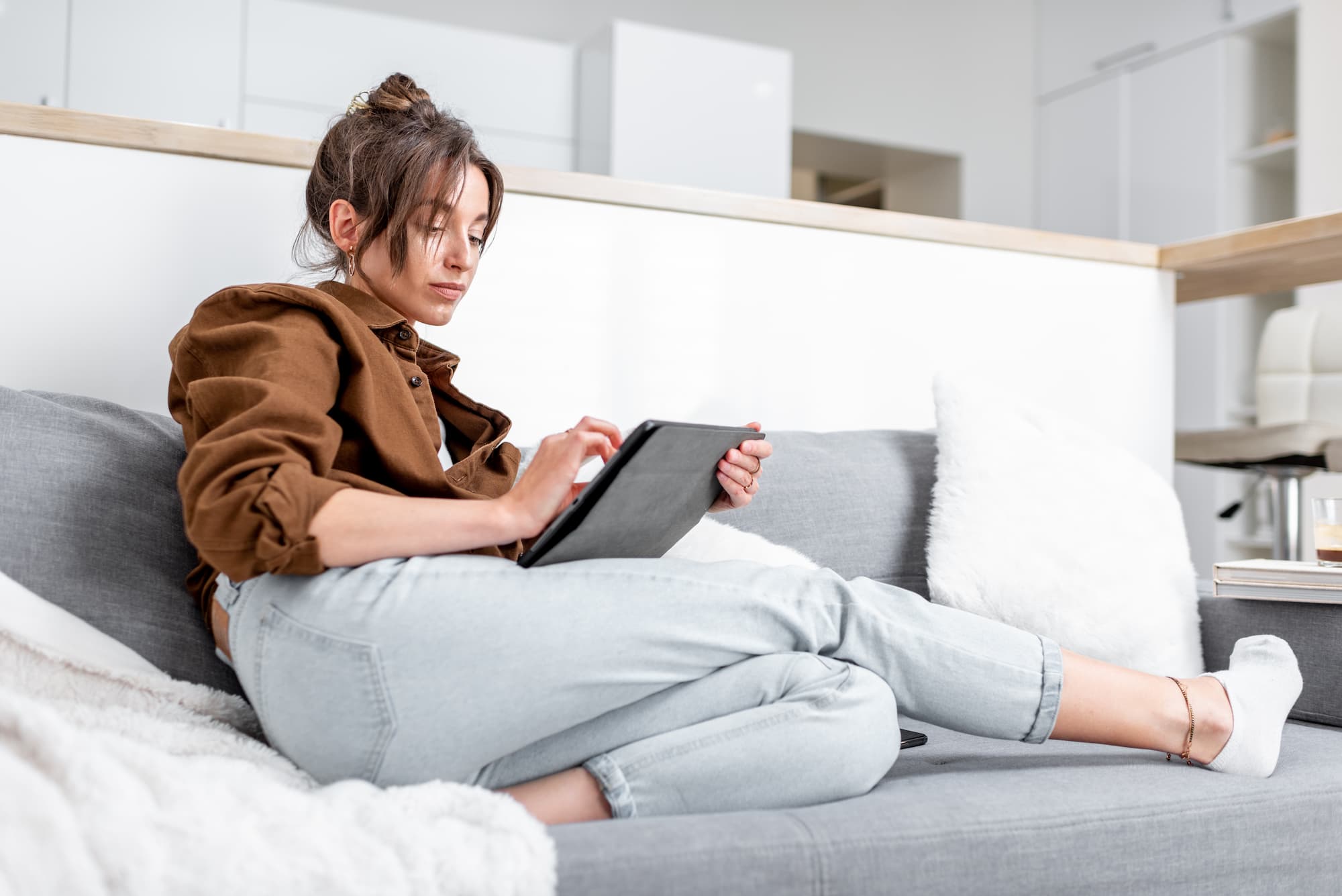 Female sitting on couch using tablet